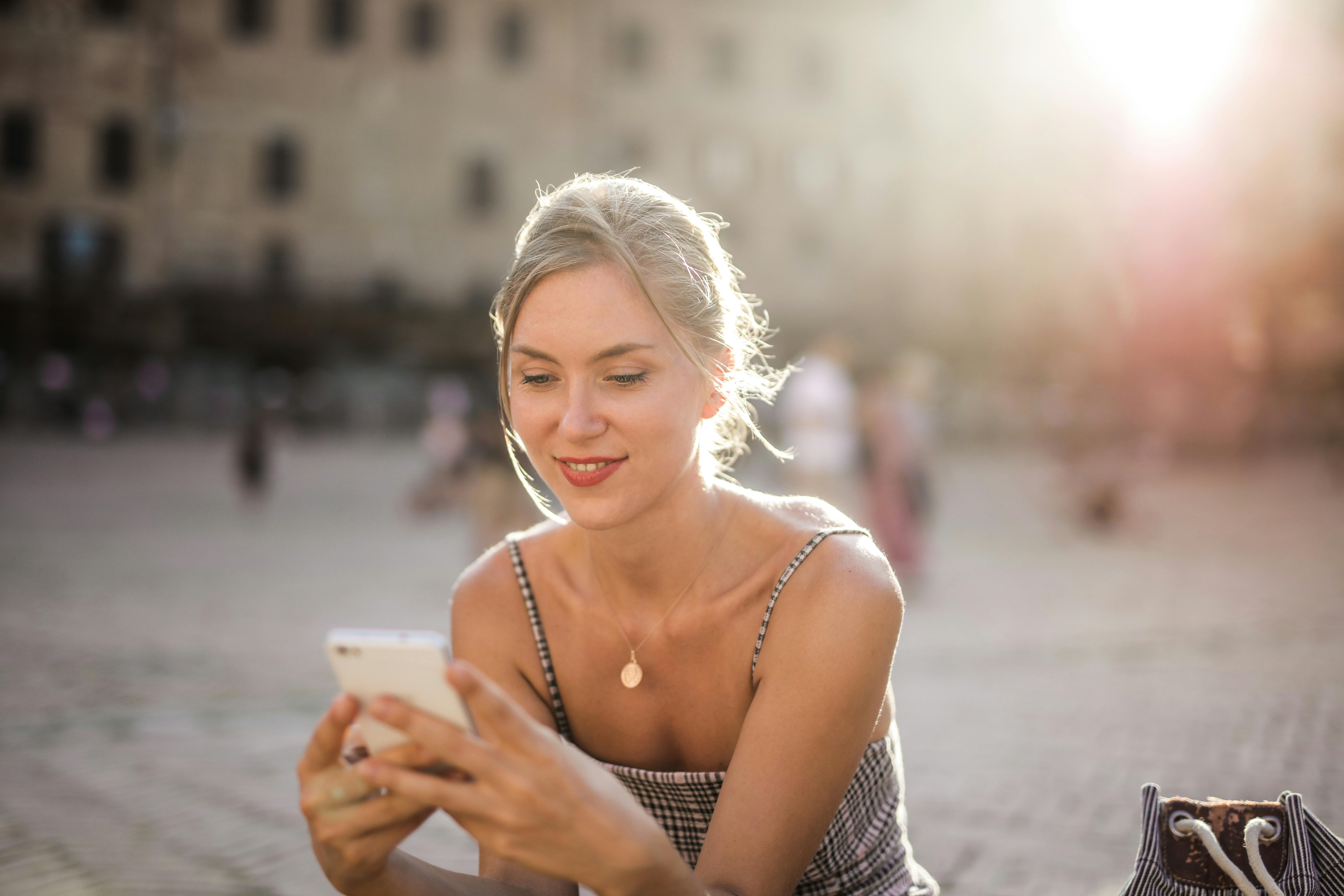 Mujer con smartphone en la mano chateando en canales digitales de una empresa